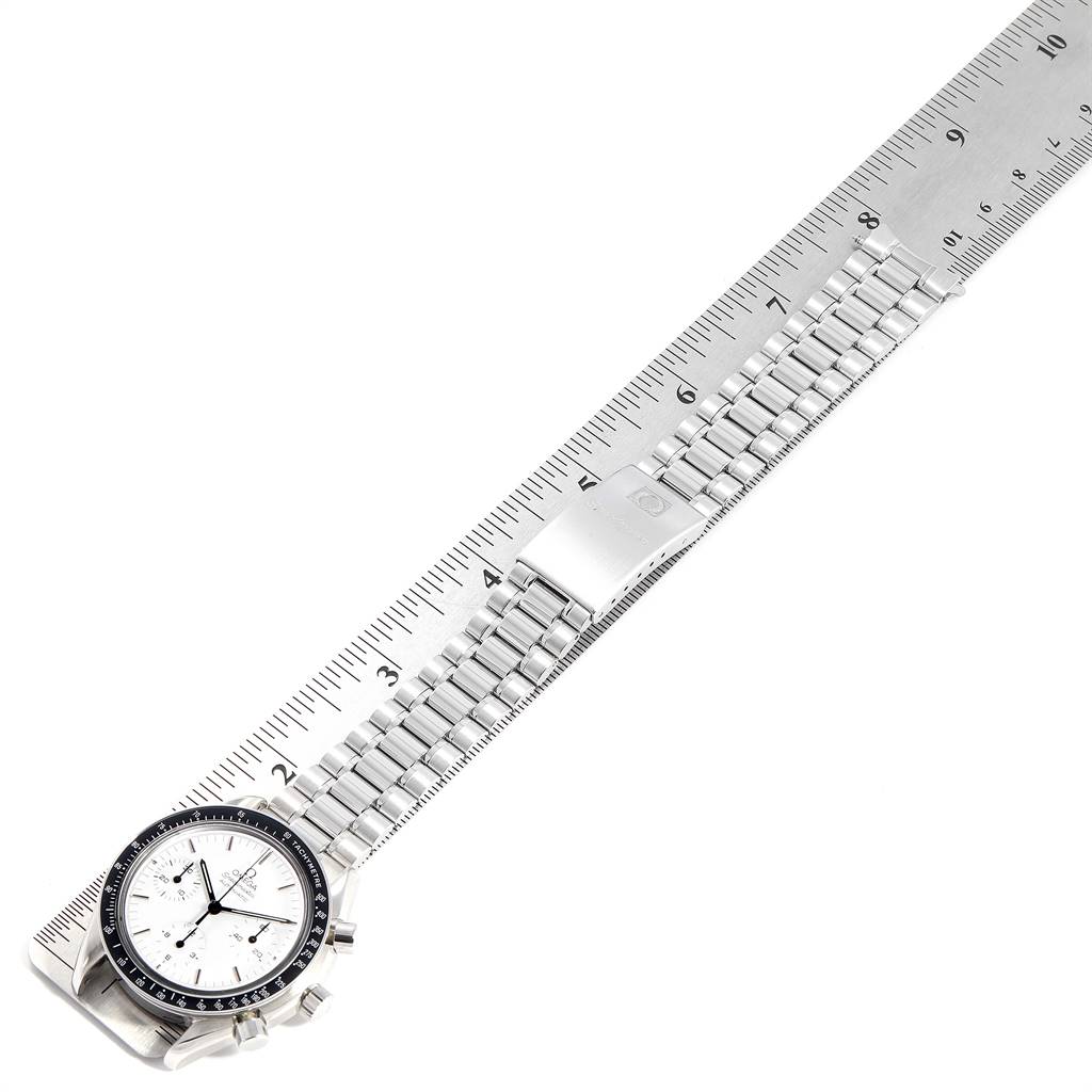 The Omega Speedmaster 3510.20.00 Men
s Stainless Steel White Dial 3510.20.00 Men
s Stainless Steel White Dial watch is shown at an angle, highlighting its face, bezel, and metal bracelet along with a ruler for scale.