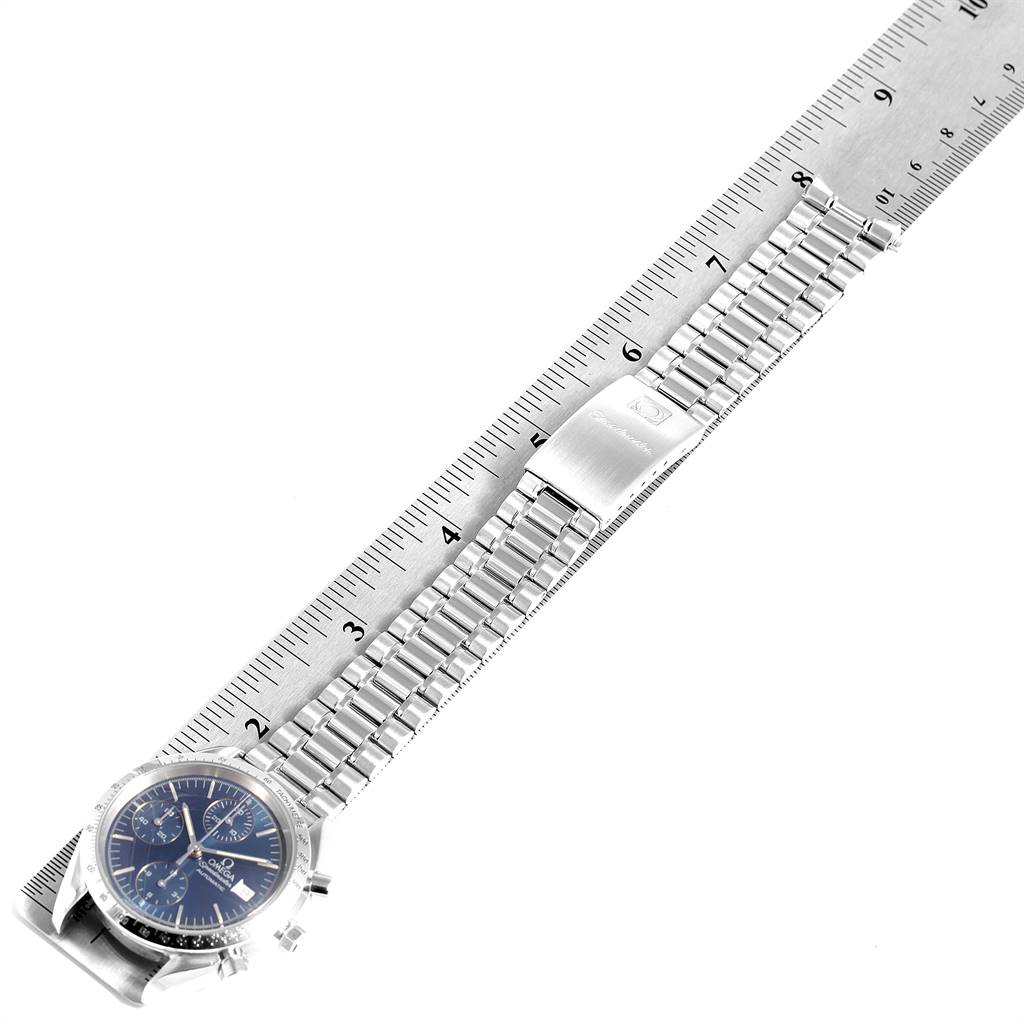 The image shows an Omega Speedmaster 3511.80.00 Men
s Stainless Steel Blue Dial 3511.80.00 Men
s Stainless Steel Blue Dial watch laid flat next to a ruler, displaying the dial and entire bracelet.