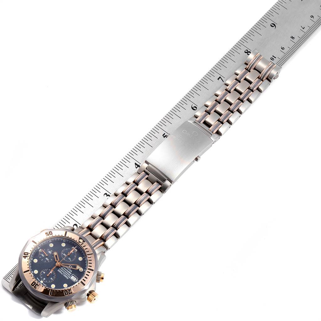 The image shows an Omega Speedmaster 2296.80.00 Men's Titanium Blue Dial 2296.80.00 Men's Titanium Blue Dial watch laid against a ruler, displaying the watch face, bezel, and strap.