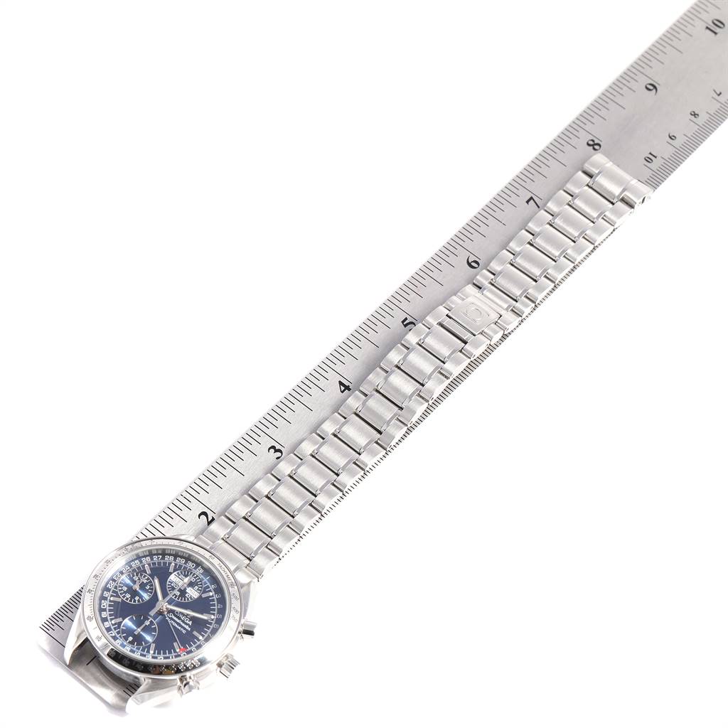 This image shows an Omega Speedmaster 3523.80.00 Men
s Stainless Steel Blue Dial 3523.80.00 Men
s Stainless Steel Blue Dial watch and its metal bracelet laid next to a ruler for scale.