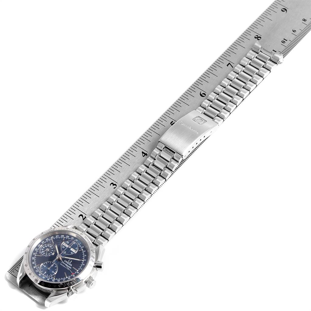 The image shows an Omega Speedmaster 3521.80.00 Men
s Stainless Steel Blue Dial 3521.80.00 Men
s Stainless Steel Blue Dial watch viewed diagonally, displaying the bracelet, clasp, and part of the dial, laid on a ruler.