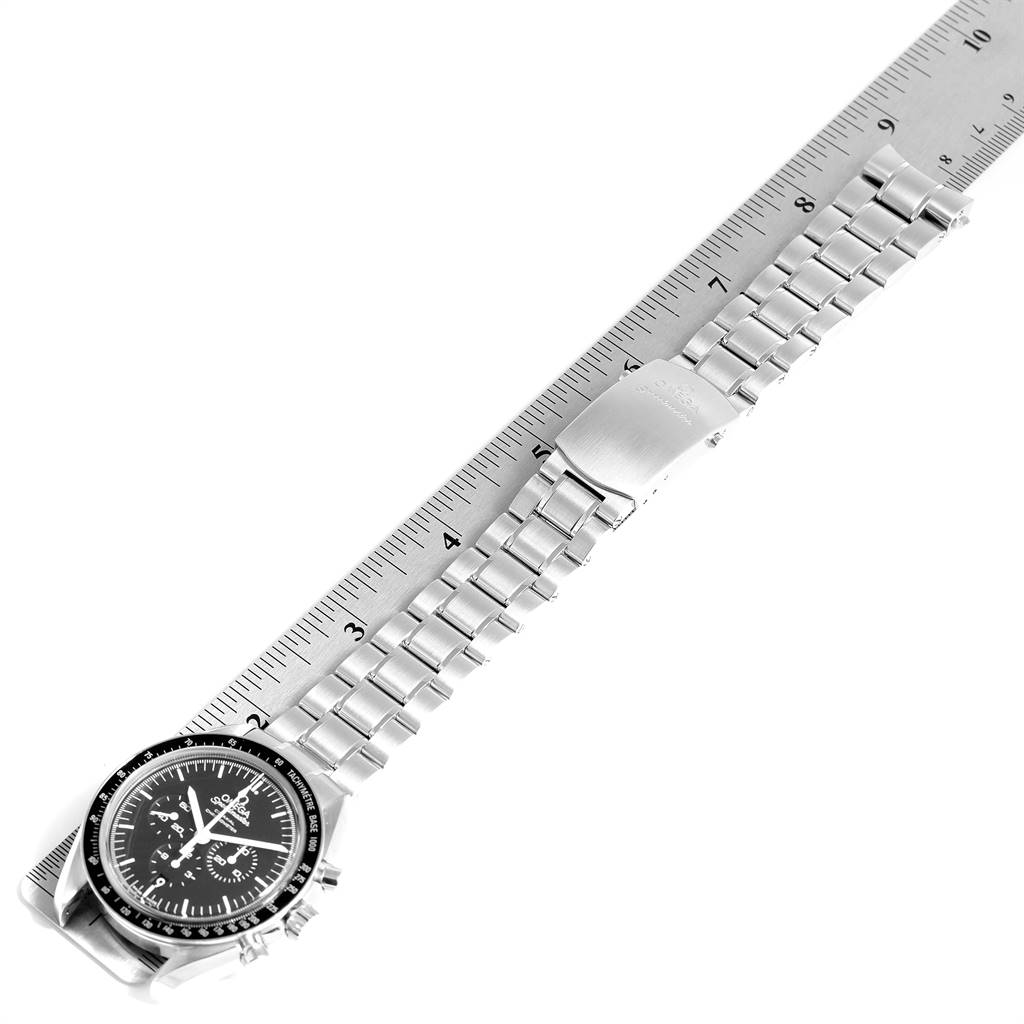 The image shows an Omega Speedmaster 311.30.44.50.01.002 Men
s Stainless Steel Black Dial 311.30.44.50.01.002 Men
s Stainless Steel Black Dial watch from an overhead angle, displaying its face, bezel, and metal bracelet laid against a ruler.