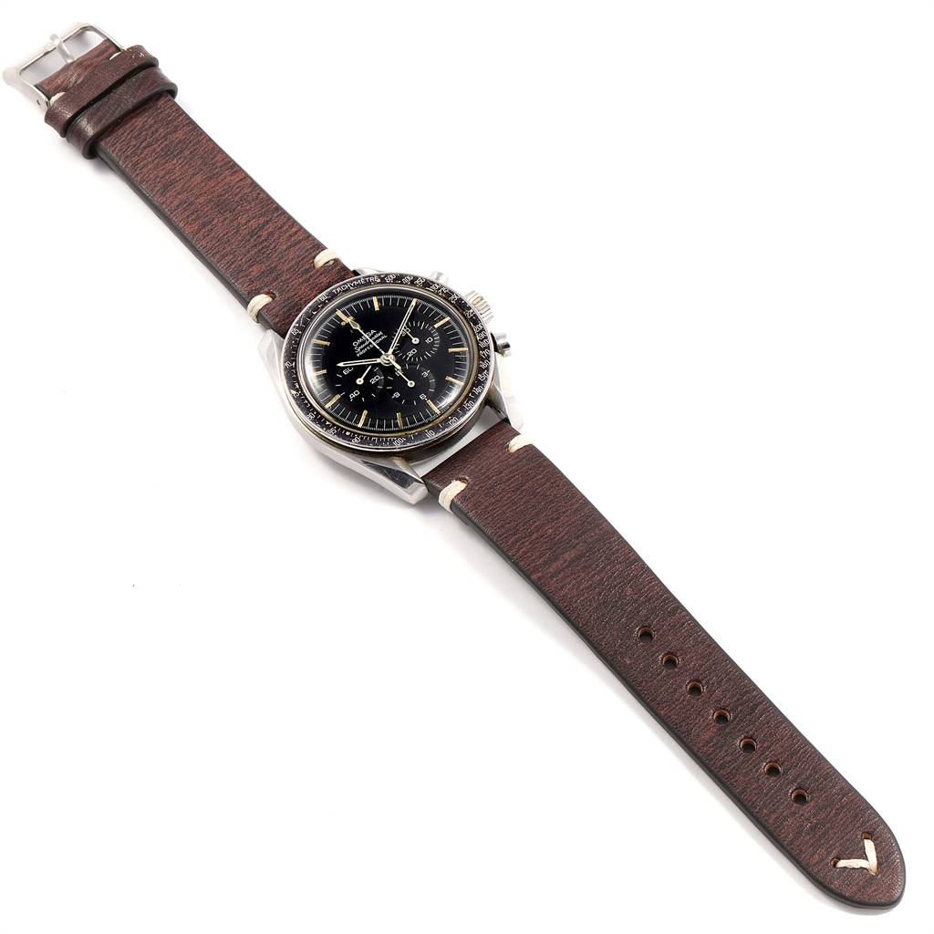 The image shows an Omega Speedmaster 145.012 Men's Stainless Steel Black Dial 145.012 Men's Stainless Steel Black Dial watch from a top-down angle, highlighting its face, bezel, and brown leather strap.