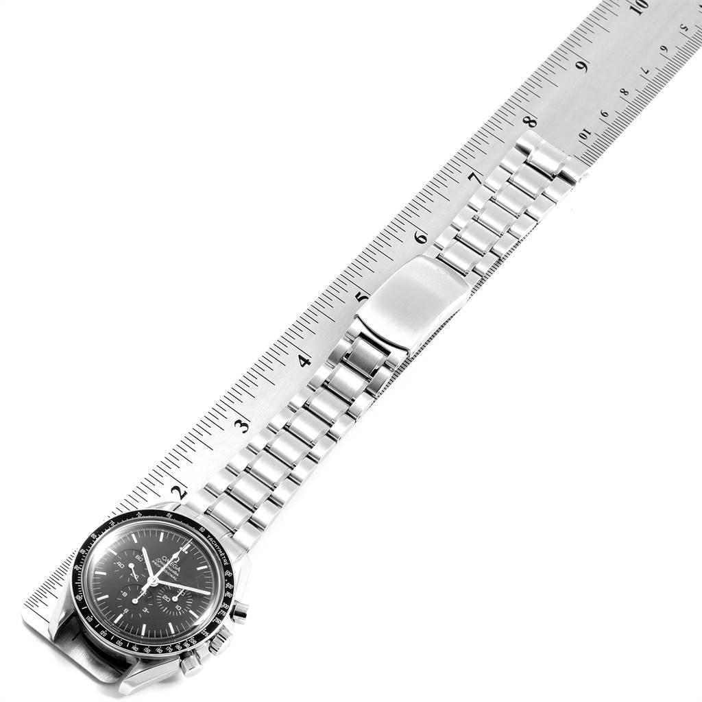 The image shows an Omega Speedmaster 3572.50.00 Men
s Stainless Steel Black Dial 3572.50.00 Men
s Stainless Steel Black Dial watch laid against a ruler, displaying the face, bezel, crown, chronograph pushers, and metal bracelet.