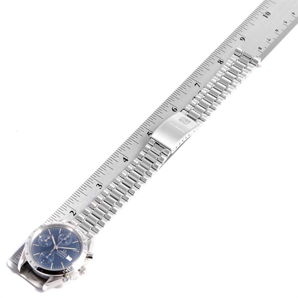 The image shows an Omega Speedmaster 3511.80.00 Men
s Stainless Steel Blue Dial 3511.80.00 Men
s Stainless Steel Blue Dial watch laid flat alongside a ruler, displaying the dial, bracelet, and clasp.
