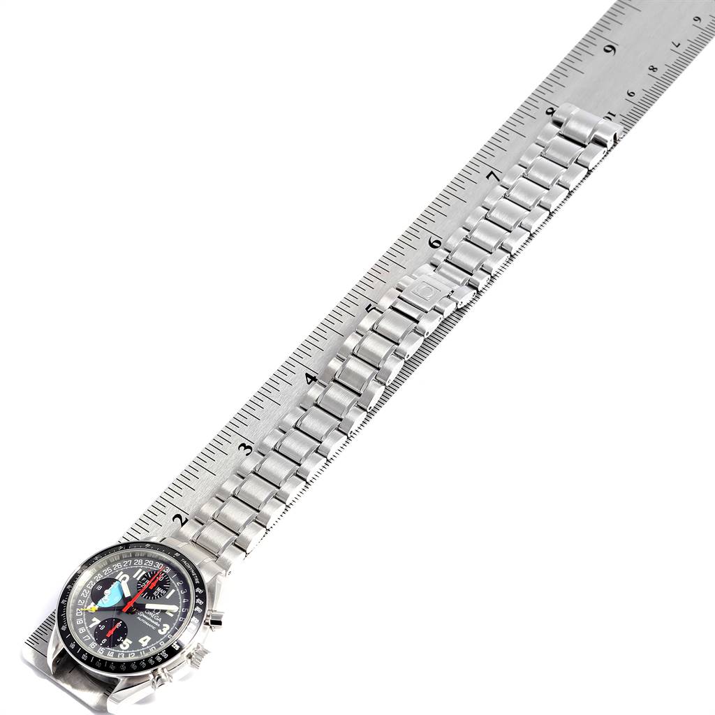 The Omega Speedmaster 3520.53.00 Men
s Stainless Steel Grey Dial 3520.53.00 Men
s Stainless Steel Grey Dial watch is shown from a top-down angle, displaying its face and metal bracelet alongside a ruler.