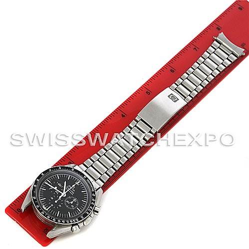 The image shows an Omega Speedmaster Men
s Stainless Steel Black Dial Men
s Stainless Steel Black Dial watch laid flat, face-up, with a stainless steel bracelet on a red ruler.