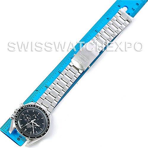 The image shows an Omega Speedmaster 3570.50.00 Men's Stainless Steel Black Dial 3570.50.00 Men's Stainless Steel Black Dial watch laid flat on a blue ruler, highlighting the face, bezel, and metal bracelet.