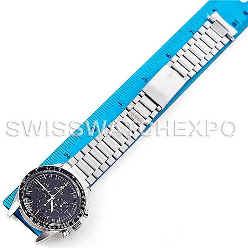 The image shows an overhead view of an Omega Speedmaster 105.003-65 Men's Stainless Steel Black Dial 105.003-65 Men's Stainless Steel Black Dial watch with a stainless steel bracelet next to a blue ruler.
