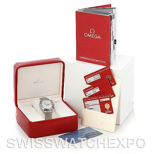 The image shows an Omega Speedmaster 3211.30.00 Men
s Stainless Steel Silver Dial 3211.30.00 Men
s Stainless Steel Silver Dial watch in its box, along with operating instructions, warranty cards, and other documents.