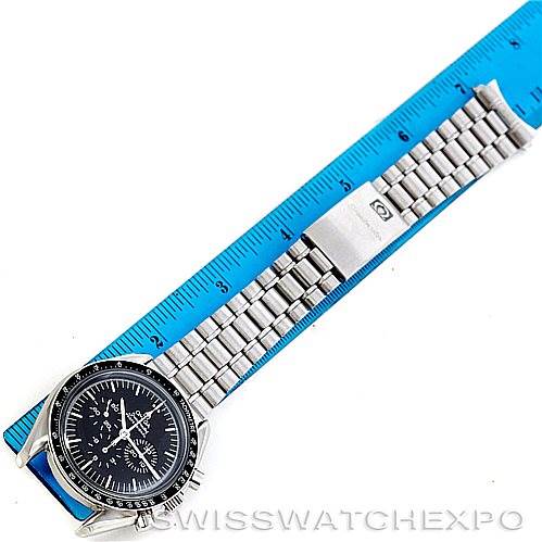 The image shows an Omega Speedmaster Men
s Stainless Steel Black Dial Men
s Stainless Steel Black Dial watch laid flat beside a blue ruler.