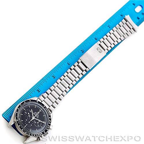 This image shows an Omega Speedmaster Men
s Stainless Steel Black Dial Men
s Stainless Steel Black Dial watch laid flat alongside a blue ruler, highlighting its stainless steel bracelet and clasp.