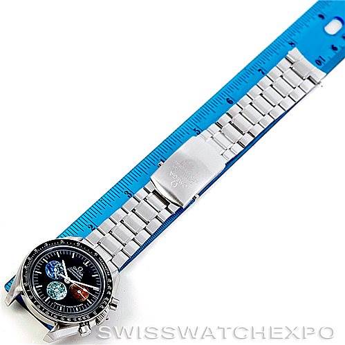 The Omega Speedmaster 3577.50.00 Men
s Stainless Steel Black Dial 3577.50.00 Men
s Stainless Steel Black Dial watch is shown from a top-down angle alongside a blue ruler, displaying the watch face and full stainless steel bracelet.