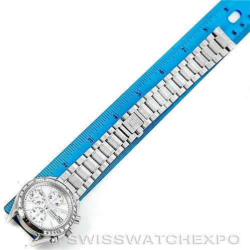 The image shows an Omega Speedmaster 3513.30.00 Men
s Stainless Steel Silver Dial 3513.30.00 Men
s Stainless Steel Silver Dial watch laid flat against a ruler, displaying its full metal bracelet and face from a top-down angle.