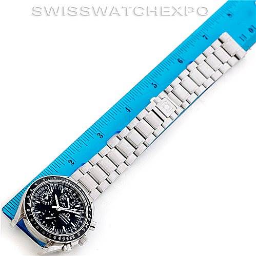 The image shows an Omega Speedmaster 3220.50.00 Men
s Stainless Steel Black Dial 3220.50.00 Men
s Stainless Steel Black Dial watch laid flat next to a blue ruler, highlighting its metal bracelet and black dial face.