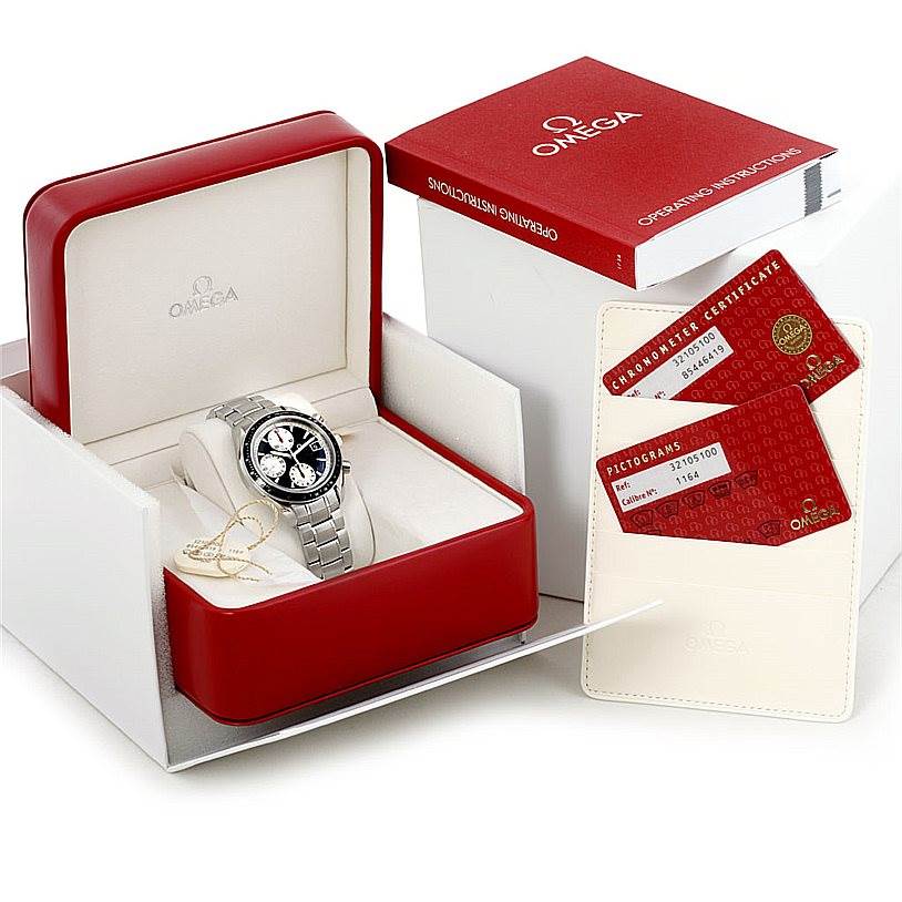 The image shows an Omega Speedmaster 3210.51.00 Men's Stainless Steel Black Dial 3210.51.00 Men's Stainless Steel Black Dial watch in its open box with certification cards and a manual.