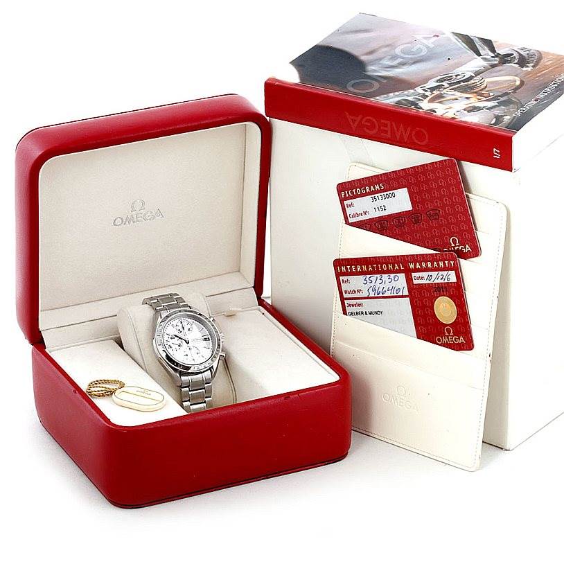 The image shows an Omega Speedmaster 3513.30.00 Men
s Stainless Steel Silver Dial 3513.30.00 Men
s Stainless Steel Silver Dial watch in its red box with warranty cards and a manual beside it.