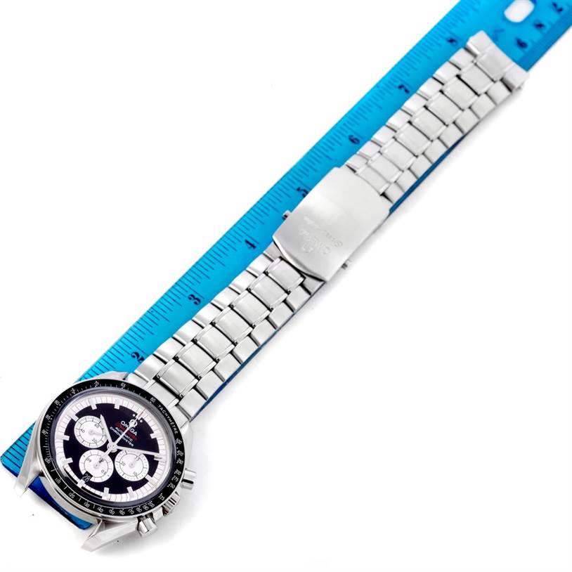 The Omega Speedmaster 3507.51.00 Men
s Stainless Steel Black Dial 3507.51.00 Men
s Stainless Steel Black Dial watch is shown from a top-down angle, displaying the dial and entire metal bracelet alongside a blue ruler.