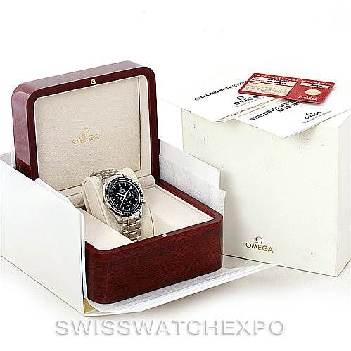 The image shows an Omega Speedmaster 3570.50.00 Men
s Stainless Steel Black Dial 3570.50.00 Men
s Stainless Steel Black Dial watch sitting in a wooden display box, with paperwork and outer packaging visible.