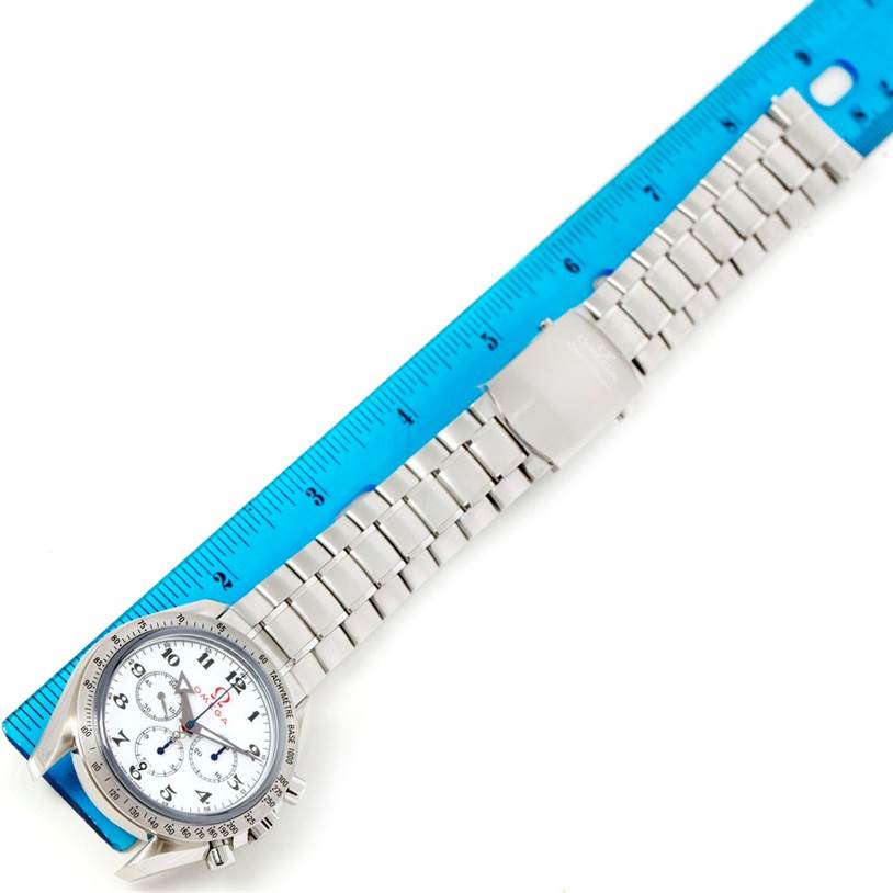 The image shows an Omega Speedmaster 321.10.42.50.04.001 Men
s Stainless Steel White Dial 321.10.42.50.04.001 Men
s Stainless Steel White Dial watch laid flat under a blue ruler, displaying the face, bracelet, and clasp.