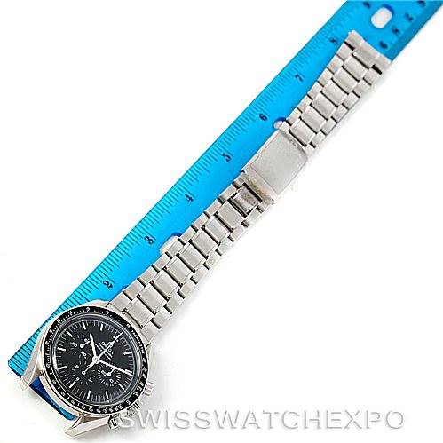 The Omega Speedmaster 3572.50.00 Men
s Stainless Steel Black Dial 3572.50.00 Men
s Stainless Steel Black Dial watch is shown from a top-down angle with its stainless steel band aligned with a blue ruler.