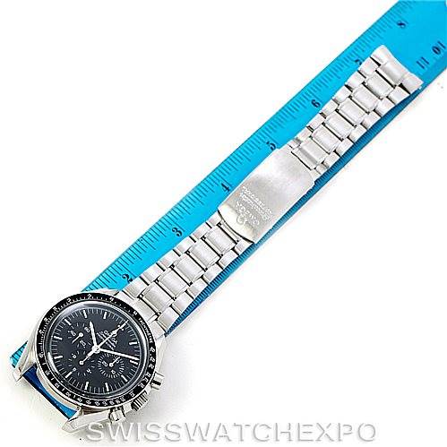 The Omega Speedmaster 3572.50.00 Men
s Stainless Steel Black Dial 3572.50.00 Men
s Stainless Steel Black Dial watch is shown from a top-down angle, highlighting its face and stainless steel bracelet alongside a blue ruler.