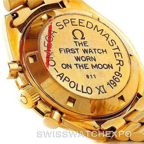 The image shows the back case of an Omega Speedmaster 145022 Men's Yellow Gold Champagne Dial 145022 Men's Yellow Gold Champagne Dial Apollo XI 1969 edition, highlighting the engraving about it being the first watch on the moon.