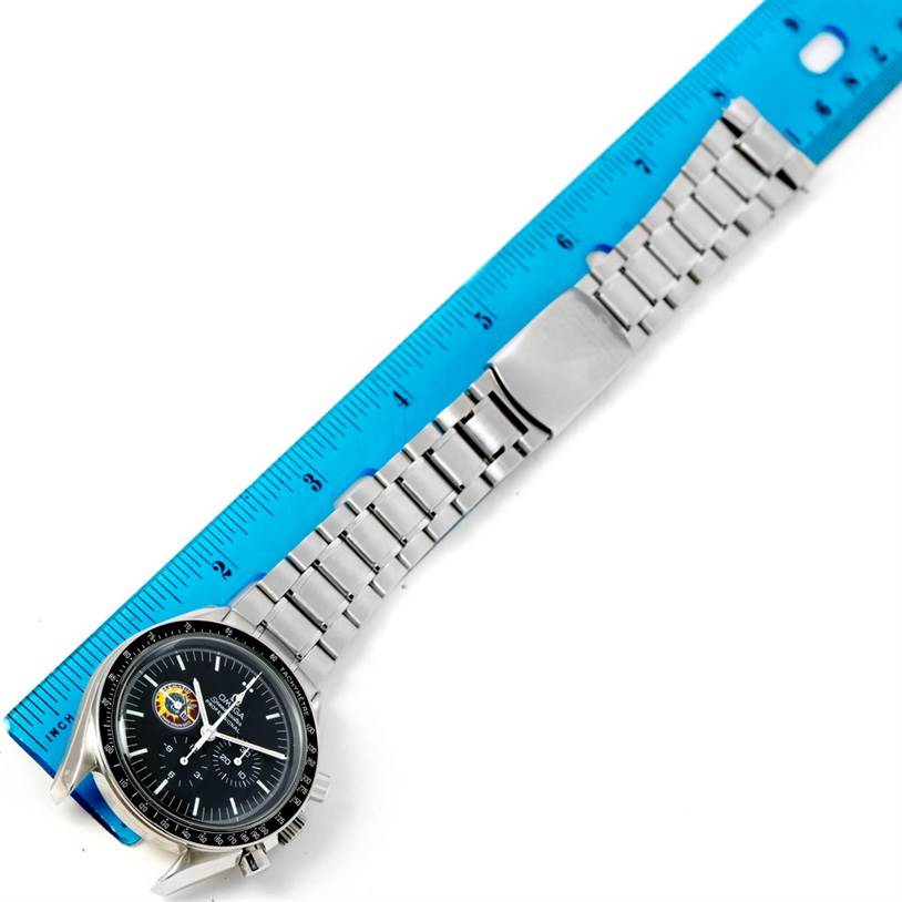 The Omega Speedmaster 3597.21.00 Men
s Stainless Steel Black Dial 3597.21.00 Men
s Stainless Steel Black Dial watch is shown at an angle, highlighting the face, bezel, and metal bracelet alongside a ruler.