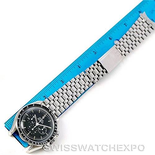 The Omega Speedmaster Men
s Stainless Steel Black Dial Men
s Stainless Steel Black Dial watch is shown from an overhead angle, displaying the face and metal bracelet alongside a blue ruler.