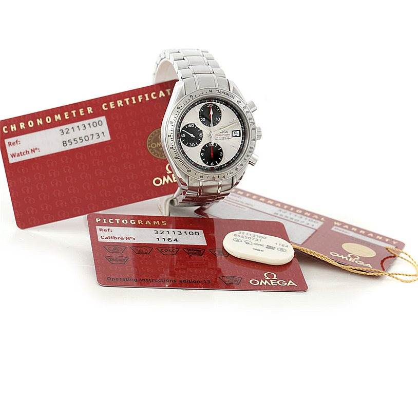 The Omega Speedmaster 3211.31.00 Men
s Stainless Steel Silver Dial 3211.31.00 Men
s Stainless Steel Silver Dial watch is shown at a slight angle with certification cards displayed underneath.
