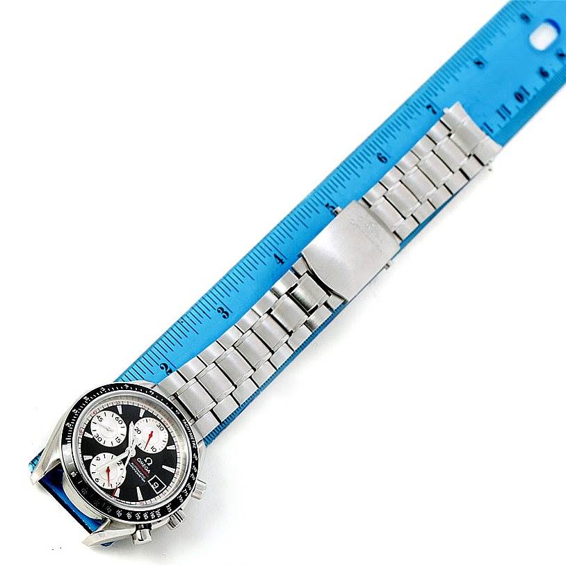 The Omega Speedmaster 3210.51.00 Men
s Stainless Steel Black Dial 3210.51.00 Men
s Stainless Steel Black Dial watch is laid flat, next to a blue ruler, showing the face, bezel, and bracelet.