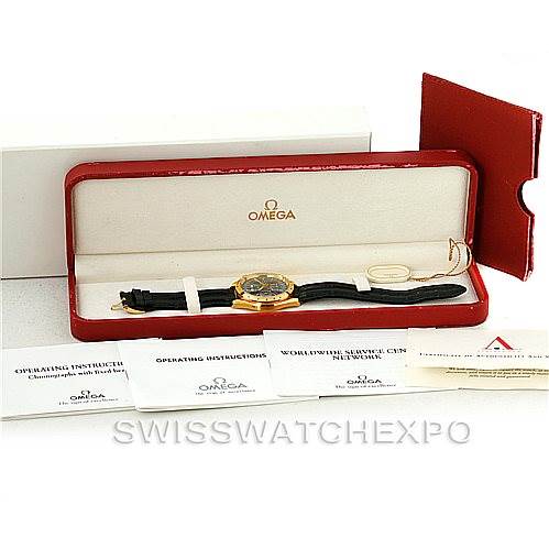 The image shows an Omega Speedmaster 3621.80.00 Men's Yellow Gold Blue Dial 3621.80.00 Men's Yellow Gold Blue Dial watch in its case, along with its operating instructions and warranty papers, viewed from a front angle.