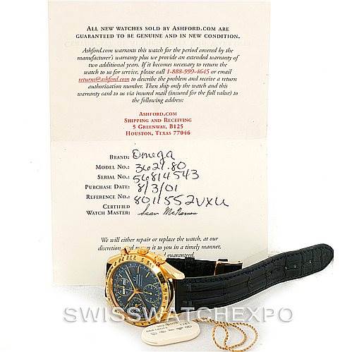The image shows an Omega Speedmaster 3621.80.00 Men's Yellow Gold Blue Dial 3621.80.00 Men's Yellow Gold Blue Dial watch laid flat with its certification papers and a tag, viewed from the front.