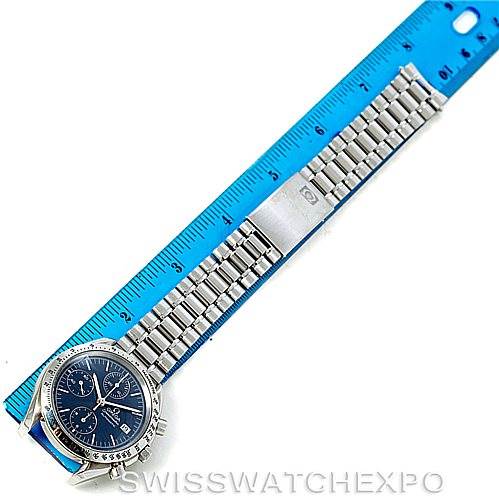 The Omega Speedmaster 3513.80.00 Men
s Stainless Steel Blue Dial 3513.80.00 Men
s Stainless Steel Blue Dial watch is shown from a top-down angle, displaying the full bracelet against a ruler.