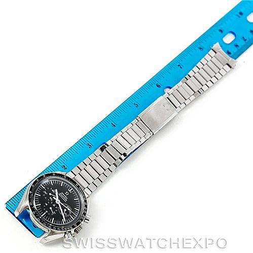 The image shows an Omega Speedmaster Men
s Stainless Steel Black Dial Men
s Stainless Steel Black Dial watch laid flat with a blue ruler beside it, displaying the watch face and metal bracelet.