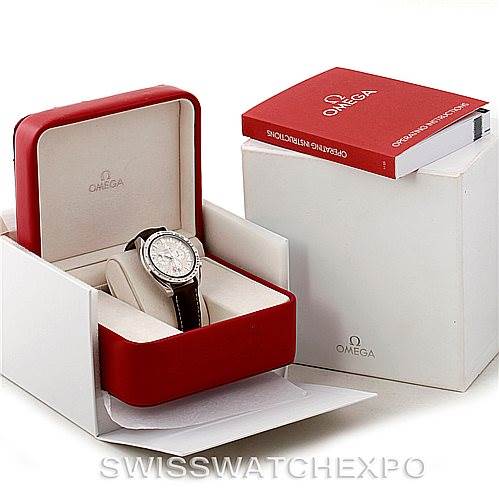The image shows an Omega Speedmaster 3881.30.37 Men
s Stainless Steel Silver Dial 3881.30.37 Men
s Stainless Steel Silver Dial watch in its open red and white box with a red Omega booklet beside it.
