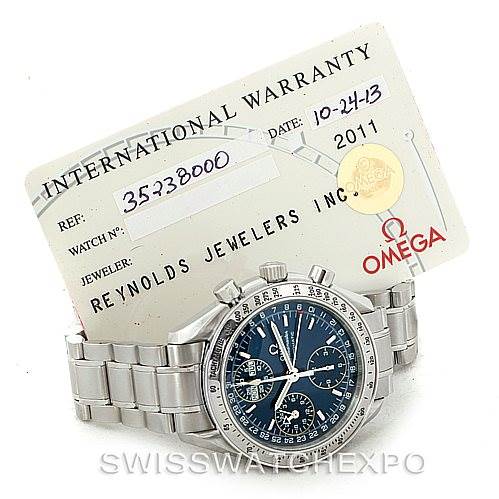 The image shows an Omega Speedmaster 3523.80.00 Men
s Stainless Steel Blue Dial 3523.80.00 Men
s Stainless Steel Blue Dial watch along with its international warranty card placed behind it.