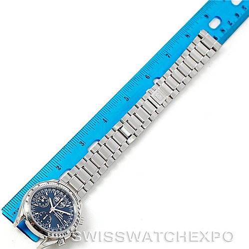 The image shows an Omega Speedmaster 3523.80.00 Men
s Stainless Steel Blue Dial 3523.80.00 Men
s Stainless Steel Blue Dial watch laid out flat next to a blue ruler, displaying the stainless steel bracelet and face.