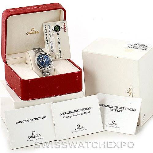 The image shows an Omega Speedmaster 3523.80.00 Men
s Stainless Steel Blue Dial 3523.80.00 Men
s Stainless Steel Blue Dial watch in its box along with operating instructions and a warranty card.