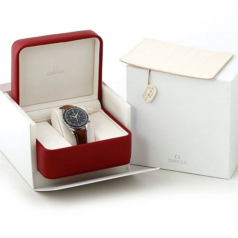 The Omega Speedmaster 311.32.40.30.01.001 Men
s Stainless Steel Black Dial 311.32.40.30.01.001 Men
s Stainless Steel Black Dial watch is shown at an angle inside its open red case, alongside its white outer box.