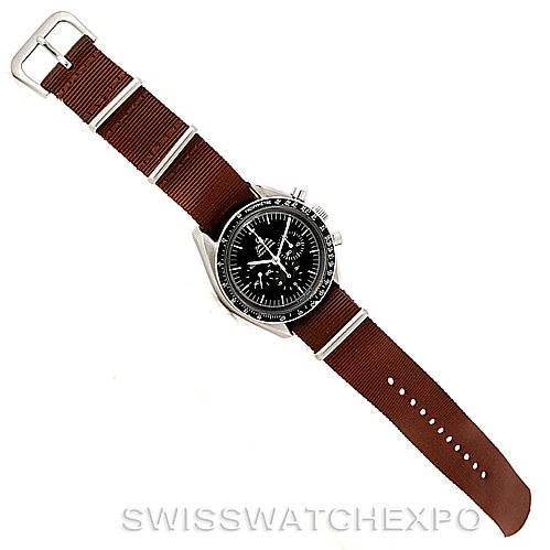 The image shows an Omega Speedmaster Men
s Stainless Steel Black Dial Men
s Stainless Steel Black Dial watch displayed flat, highlighting the dial, bezel, and brown fabric strap.