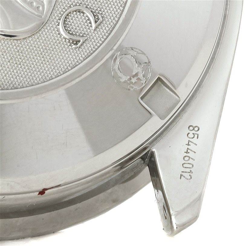 The image shows a close-up of the case back of an Omega Speedmaster 3210.52.00 Men
s Stainless Steel Black Dial 3210.52.00 Men
s Stainless Steel Black Dial watch, highlighting the Omega logo and part of the serial number.