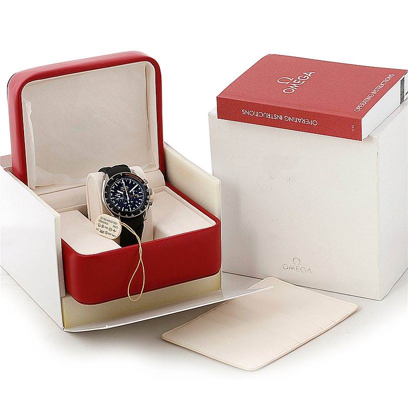 The image shows an Omega Speedmaster 321.92.44.52.01.001 Men
s Titanium Black Dial 321.92.44.52.01.001 Men
s Titanium Black Dial watch in its box, alongside operating instructions and additional packaging.