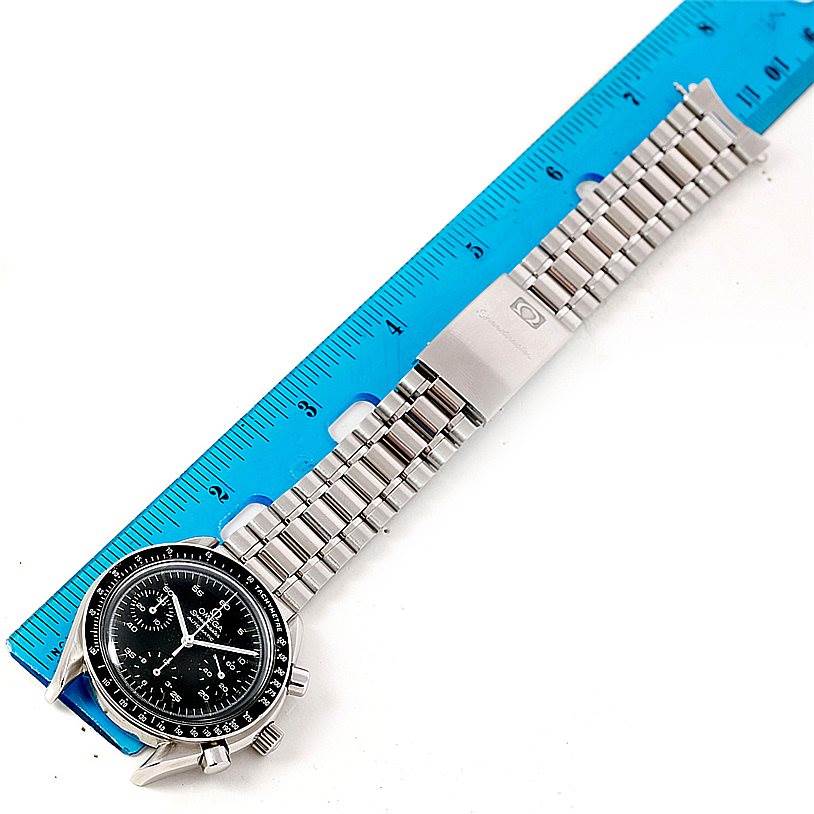 The Omega Speedmaster 3510.50.00 Men
s Stainless Steel Black Dial 3510.50.00 Men
s Stainless Steel Black Dial watch is shown from a top-down angle alongside a measurement ruler, displaying its face and stainless steel bracelet.