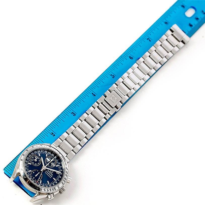 The image shows an Omega Speedmaster 3523.80.00 Men
s Stainless Steel Blue Dial 3523.80.00 Men
s Stainless Steel Blue Dial watch at a top-down angle, aligned with a ruler, displaying the face and metal bracelet.