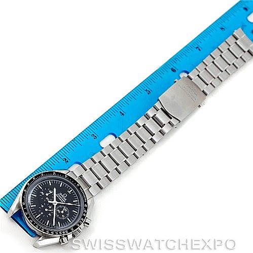 The image shows a horizontal view of an Omega Speedmaster 3570.50.00 Men
s Stainless Steel Black Dial 3570.50.00 Men
s Stainless Steel Black Dial watch with its stainless steel bracelet placed beside a blue ruler.