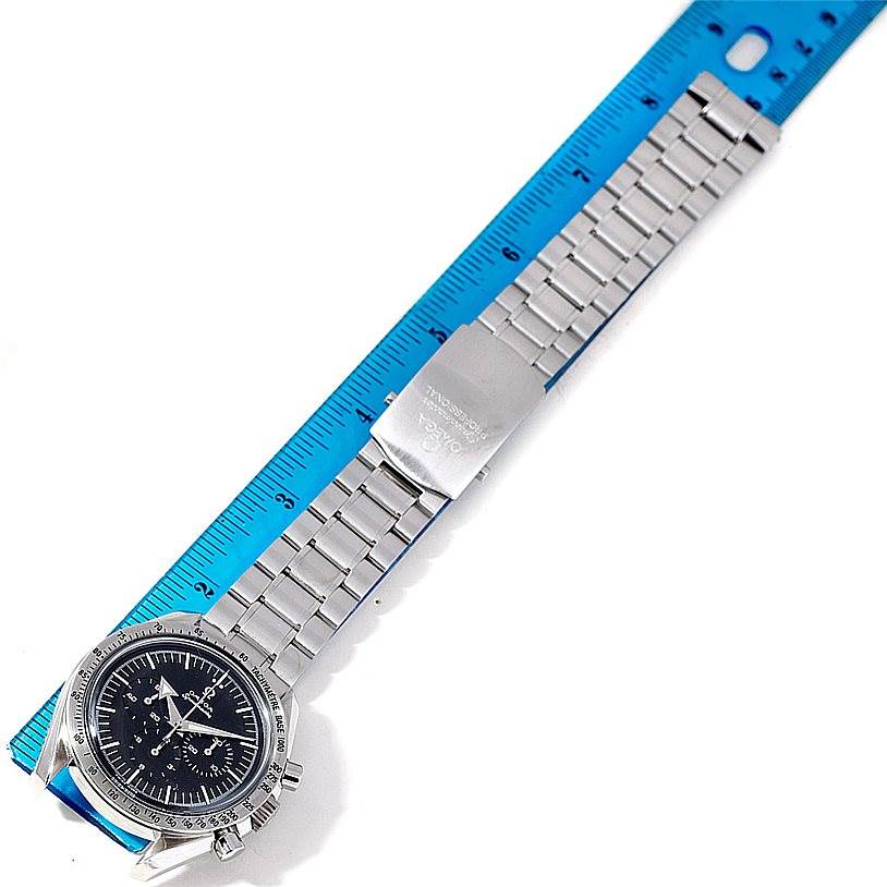 The image shows an Omega Speedmaster 3594.50.00 Men
s Stainless Steel Black Dial 3594.50.00 Men
s Stainless Steel Black Dial watch laid flat with its metal bracelet extended beside a blue ruler.