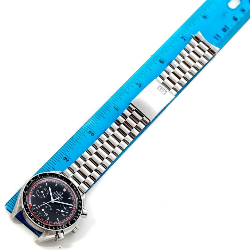 This image shows an Omega Speedmaster 3518.50.00 Men
s Stainless Steel Black Dial 3518.50.00 Men
s Stainless Steel Black Dial watch laid out flat along a blue ruler, displaying its face and metal band.