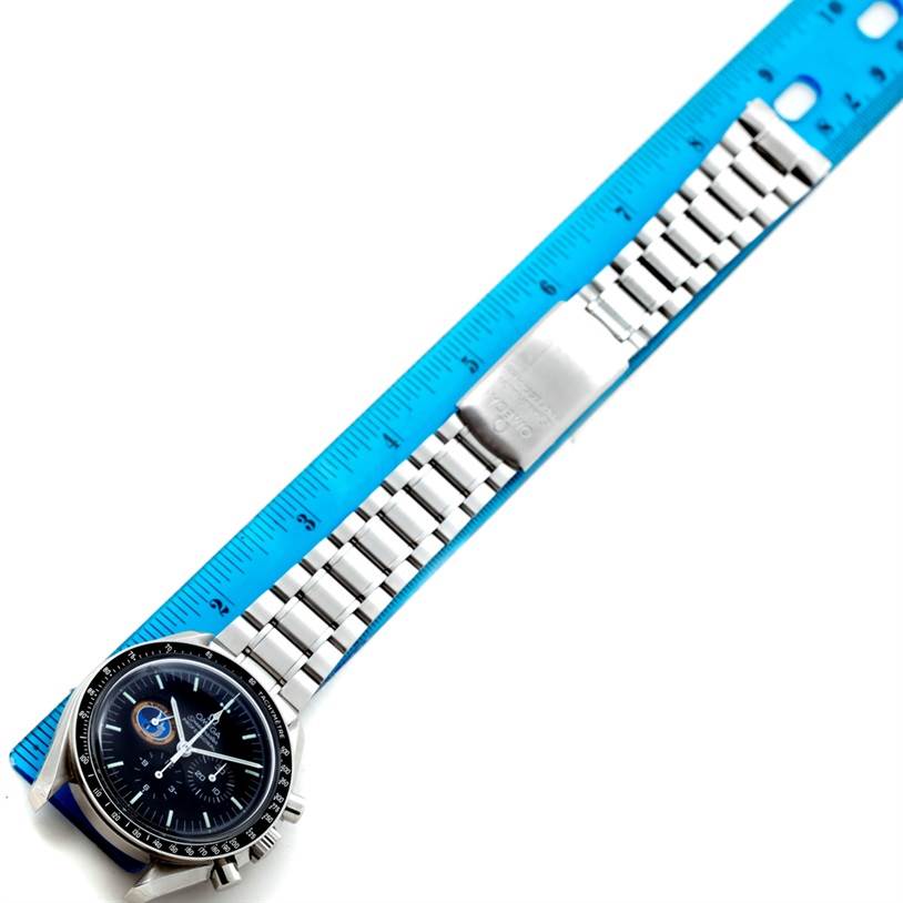 The Omega Speedmaster 3597.17 Men
s Stainless Steel Black Dial 3597.17 Men
s Stainless Steel Black Dial watch is shown lying flat, displaying its face, bracelet, and clasp next to a blue ruler.