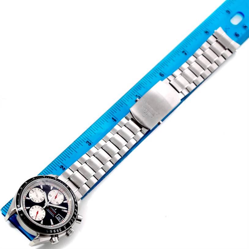 The image shows an Omega Speedmaster 3210.51.00 Men
s Stainless Steel Black Dial 3210.51.00 Men
s Stainless Steel Black Dial watch laid flat with the strap extended next to a blue ruler for measurement.